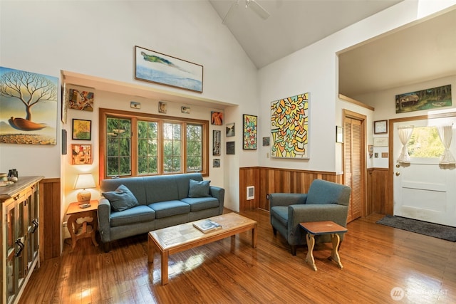 3404 Oysterville Rd, Oysterville, WA 98641 - living area featuring wainscoting, high vaulted ceiling, wood walls, and hardwood / wood-style floors