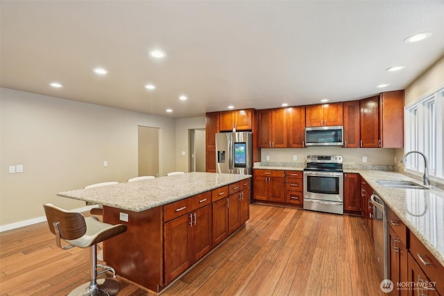 24010 SE 168th St, Issaquah, WA 98027 - kitchen featuring stainless steel appliances, a sink, recessed lighting, light wood finished floors, and a center island
