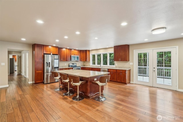 24010 SE 168th St, Issaquah, WA 98027 - kitchen with appliances with stainless steel finishes, light wood-style floors, french doors, a kitchen island, and baseboards