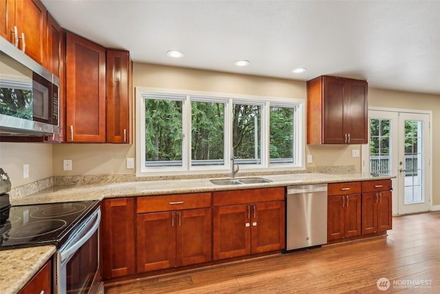 24010 SE 168th St, Issaquah, WA 98027 - kitchen featuring stainless steel appliances, a sink, light wood-type flooring, recessed lighting, and light stone counters
