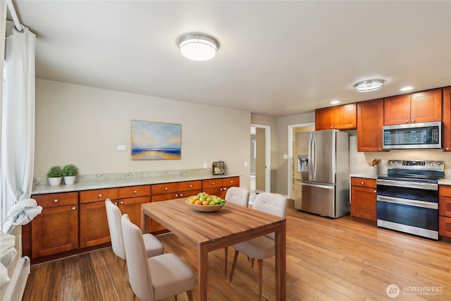 24010 SE 168th St, Issaquah, WA 98027 - kitchen with appliances with stainless steel finishes, light wood-type flooring, brown cabinets, recessed lighting, and light stone counters