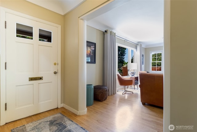 entryway with baseboards and light wood-style flooring