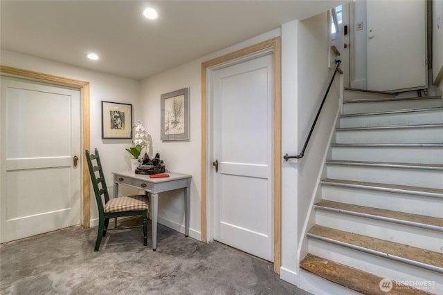 stairs featuring concrete floors and recessed lighting
