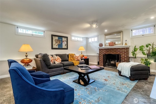 living room featuring finished concrete flooring, baseboards, and a fireplace