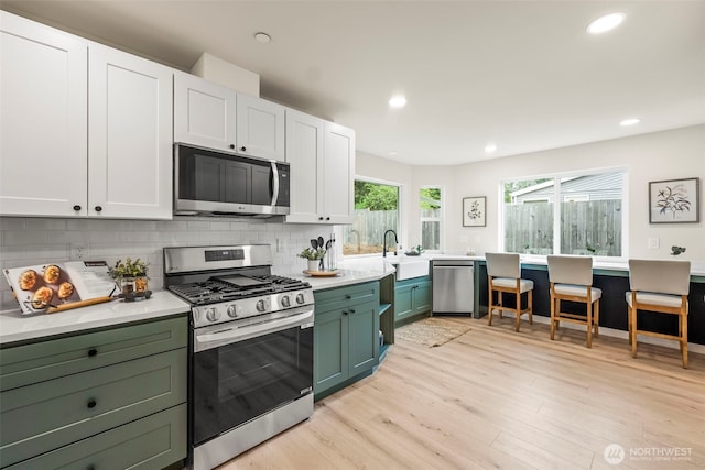 19713 17th St SW, Lakebay, WA 98349 - kitchen with appliances with stainless steel finishes, green cabinets, a sink, tasteful backsplash, and recessed lighting