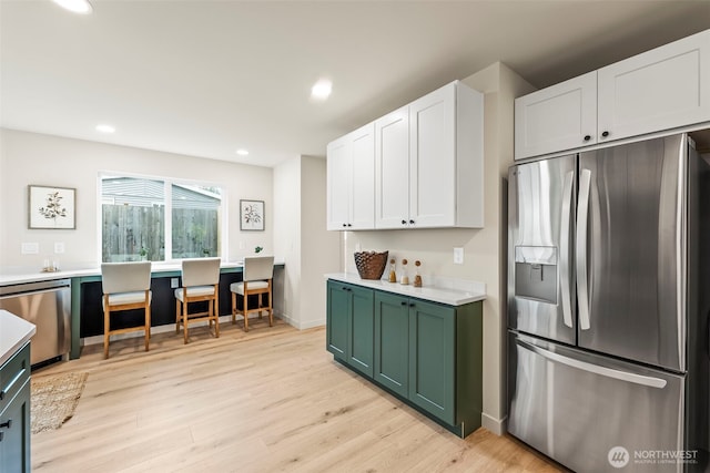 19713 17th St SW, Lakebay, WA 98349 - kitchen with appliances with stainless steel finishes, green cabinetry, light wood-style floors, white cabinetry, and light countertops