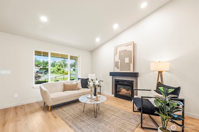 19713 17th St SW, Lakebay, WA 98349 - living area featuring vaulted ceiling, a glass covered fireplace, light wood-style floors, recessed lighting, and baseboards