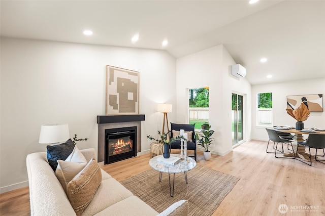 19713 17th St SW, Lakebay, WA 98349 - living room featuring a wall unit AC, a glass covered fireplace, recessed lighting, light wood-style floors, and lofted ceiling