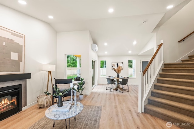 19713 17th St SW, Lakebay, WA 98349 - living room with stairs, lofted ceiling, light wood-style floors, a tiled fireplace, and a wall mounted air conditioner