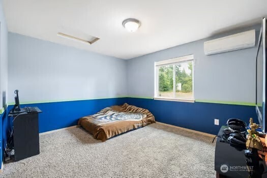 231 E Heights Pl N, Belfair, WA 98528 - carpeted bedroom featuring an AC wall unit and attic access