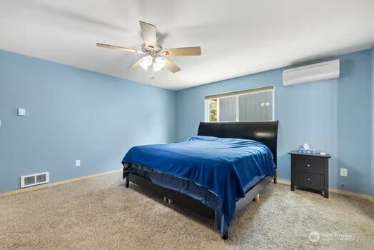 231 E Heights Pl N, Belfair, WA 98528 - bedroom featuring an AC wall unit, carpet floors, and ceiling fan