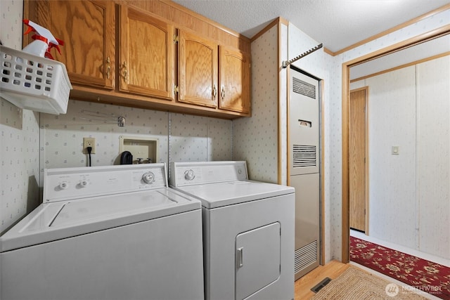 1340 Gloria Ln, Walla Walla, WA 99362 - laundry room with light wood-style flooring, independent washer and dryer, wallpapered walls, and cabinet space