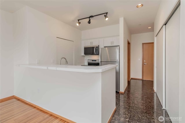 668S Lane St Unit 702, Seattle, WA 98104 - kitchen featuring white cabinets, a peninsula, stainless steel appliances, recessed lighting, and granite finish floor