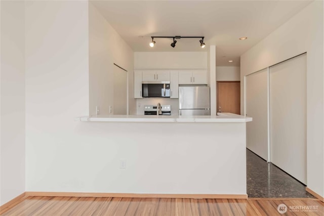 668S Lane St Unit 702, Seattle, WA 98104 - kitchen with white cabinetry, light countertops, recessed lighting, a peninsula, and appliances with stainless steel finishes