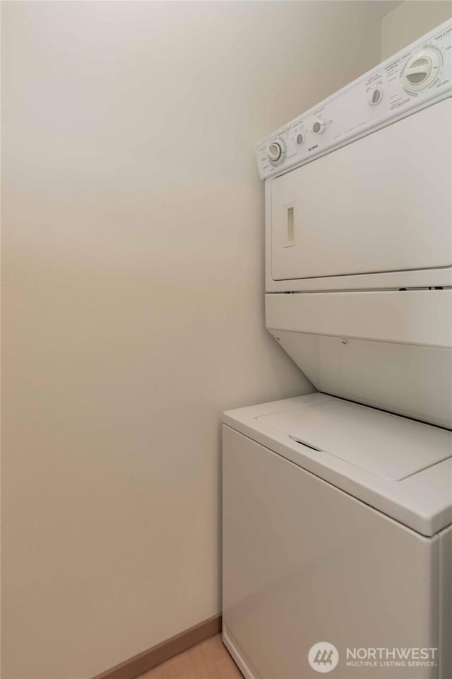 668S Lane St Unit 702, Seattle, WA 98104 - clothes washing area with baseboards, stacked washer / dryer, and laundry area
