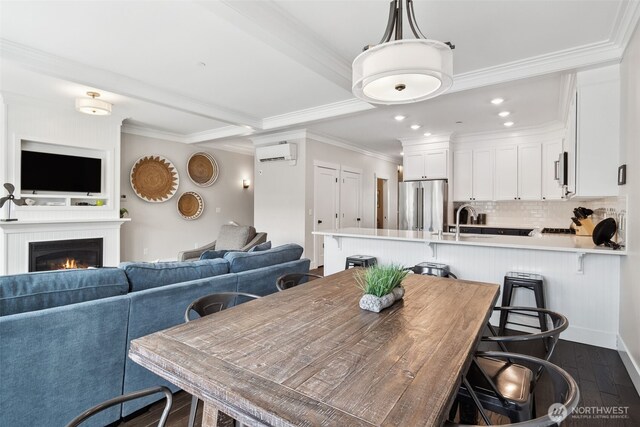 211 Market St, Pacific Beach, WA 98571 - dining area with crown molding, dark wood finished floors, a lit fireplace, recessed lighting, and a wall mounted AC