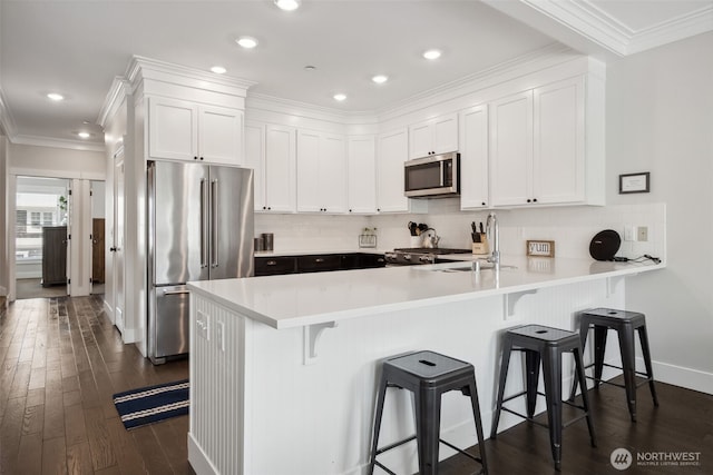 211 Market St, Pacific Beach, WA 98571 - kitchen with a peninsula, a sink, white cabinetry, and stainless steel appliances