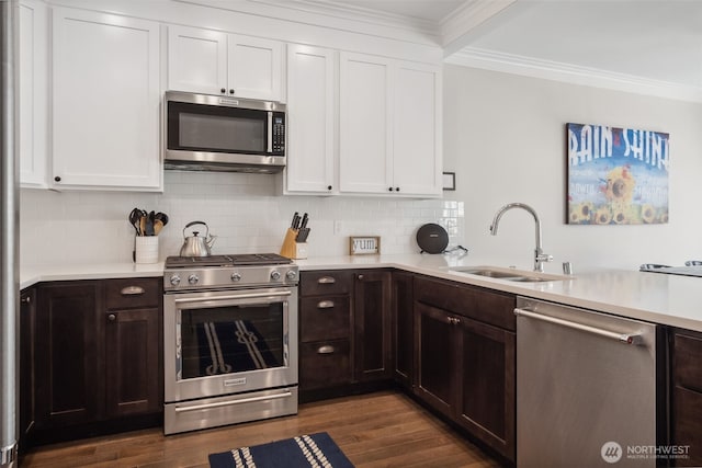 211 Market St, Pacific Beach, WA 98571 - kitchen featuring crown molding, white cabinets, appliances with stainless steel finishes, light countertops, and a sink