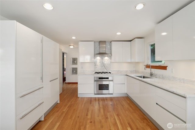 3754 SW 107th St, Seattle, WA 98146 - kitchen featuring stainless steel appliances, a sink, modern cabinets, wall chimney range hood, and recessed lighting