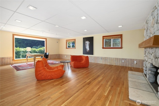 3754 SW 107th St, Seattle, WA 98146 - living area with a wainscoted wall, wood finished floors, wooden walls, a fireplace, and healthy amount of natural light