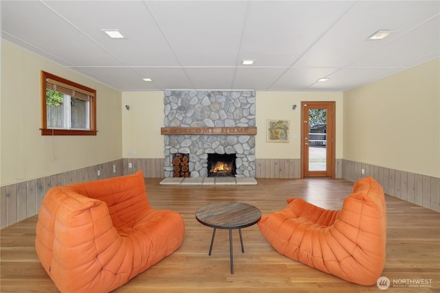 3754 SW 107th St, Seattle, WA 98146 - living room featuring wainscoting, a stone fireplace, wood finished floors, wood walls, and recessed lighting