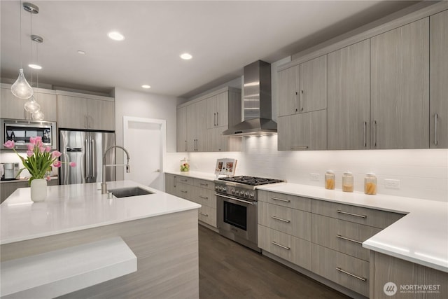 kitchen featuring wall chimney exhaust hood, appliances with stainless steel finishes, a sink, modern cabinets, and light countertops