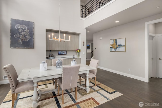 dining area with wood finished floors, a chandelier, and baseboards