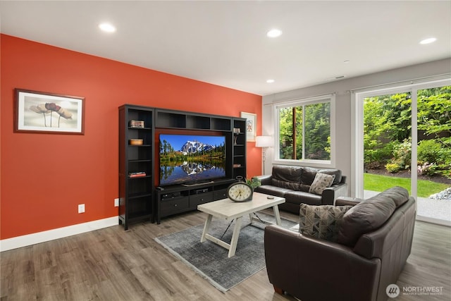 living area with healthy amount of natural light, wood finished floors, recessed lighting, and baseboards