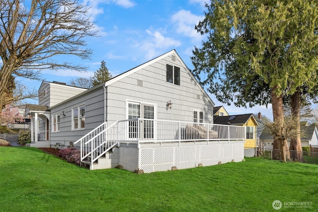rear view of property with a yard and fence