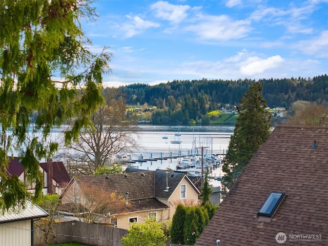 water view featuring a wooded view and fence