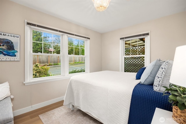 bedroom featuring baseboards and wood finished floors