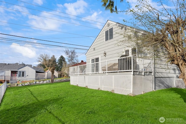 back of house featuring a yard, a wooden deck, and fence