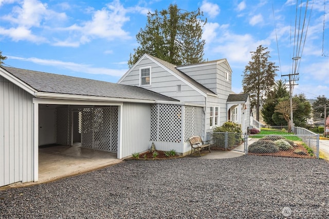 exterior space featuring fence, a gate, and roof with shingles