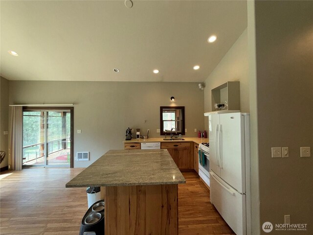 21 Twin Lakes Dr, Winthrop, WA 98862 - kitchen featuring white appliances, a kitchen island, light wood-type flooring, recessed lighting, and a breakfast bar