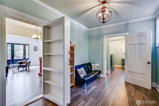 foyer entrance with an inviting chandelier, baseboards, crown molding, and wood finished floors