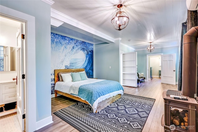 bedroom with a chandelier, ornamental molding, a wall mounted air conditioner, and hardwood / wood-style floors