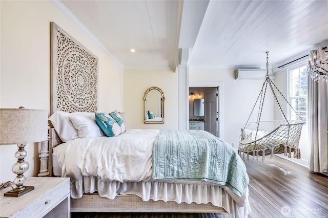 bedroom with crown molding, ensuite bathroom, a wall mounted air conditioner, and wood finished floors
