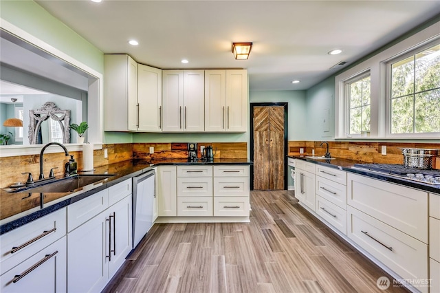 kitchen featuring a sink, white cabinets, stainless steel appliances, and visible vents
