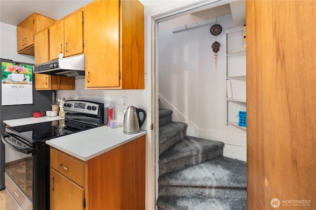2824 Pacific Ave, Hoquiam, WA 98550 - kitchen with brown cabinets, light countertops, under cabinet range hood, and stainless steel electric stove