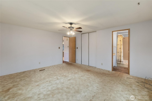 carpeted empty room with visible vents and a ceiling fan