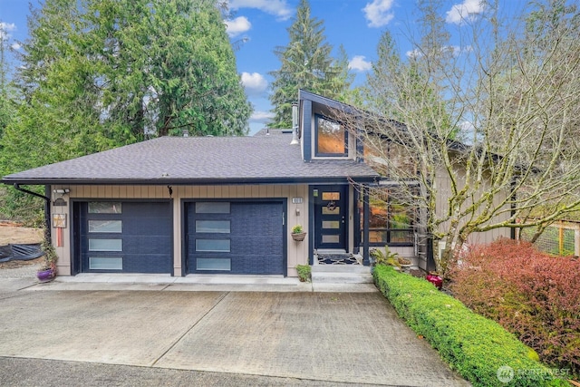 view of front of property with a garage, board and batten siding, and roof with shingles