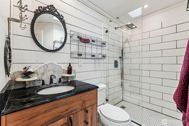 full bath with toilet, a tile shower, and vanity