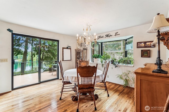 dining room with a wealth of natural light, a chandelier, and light wood-type flooring