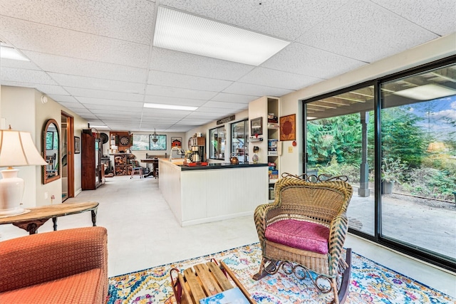 living room with light floors and a paneled ceiling