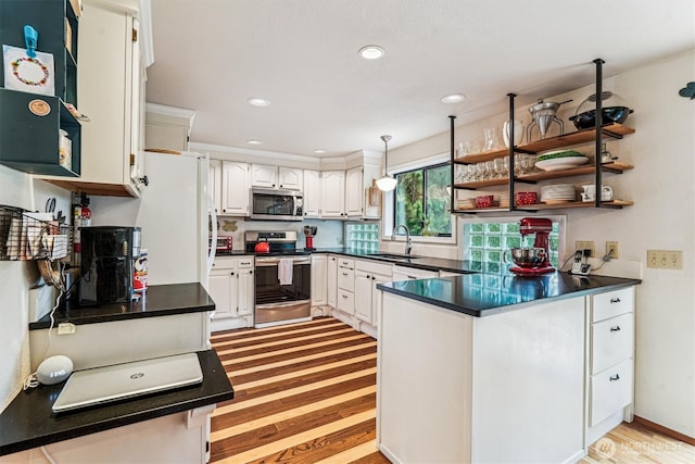 kitchen with white cabinetry, open shelves, a sink, a peninsula, and appliances with stainless steel finishes