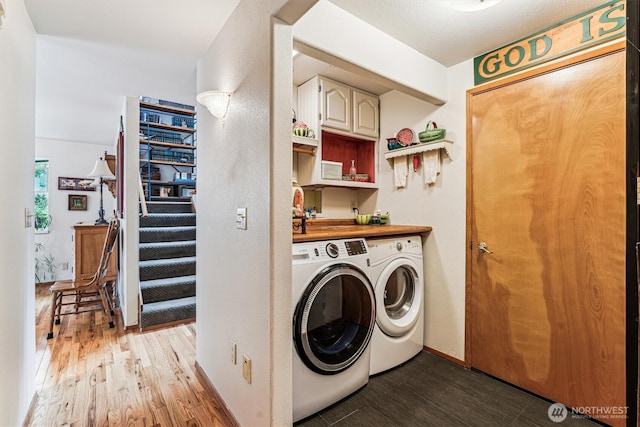 washroom featuring baseboards, laundry area, washer and clothes dryer, and light wood finished floors