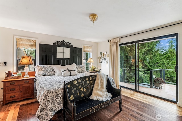 bedroom featuring multiple windows, hardwood / wood-style flooring, and access to outside