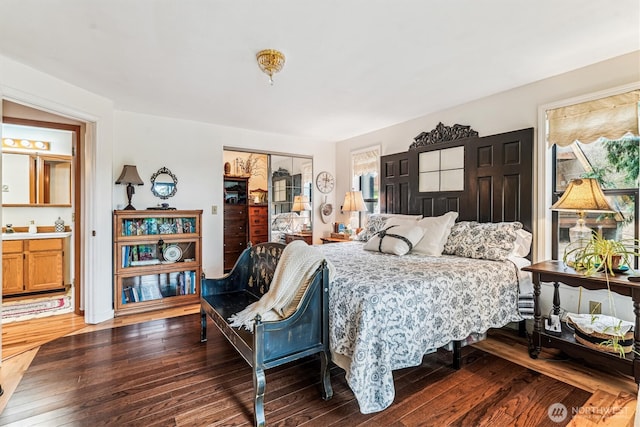bedroom featuring a closet, ensuite bathroom, and hardwood / wood-style floors
