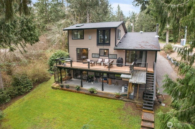 back of house featuring a wooden deck, a patio, stairway, and a lawn