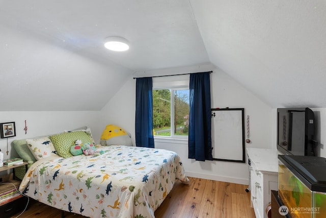 bedroom featuring baseboards, lofted ceiling, and wood finished floors